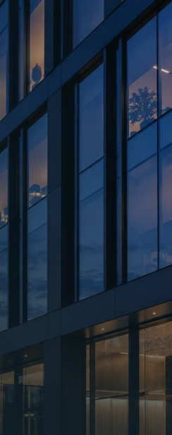 Glasfassade eines Bürogebäudes in der Abenddämmerung